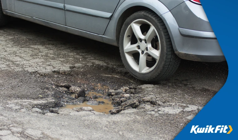 Car in large pothole